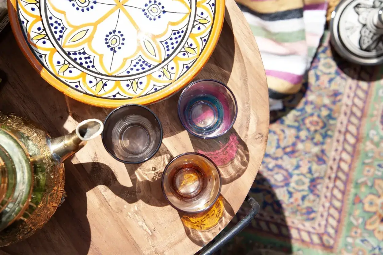 Zaparz herbatę w mosiężnym imbryku, by poczuć prawdziwy styl marokański. Kolorowe szklanki i talerz zapraszają do wspólnego biesiadowania.