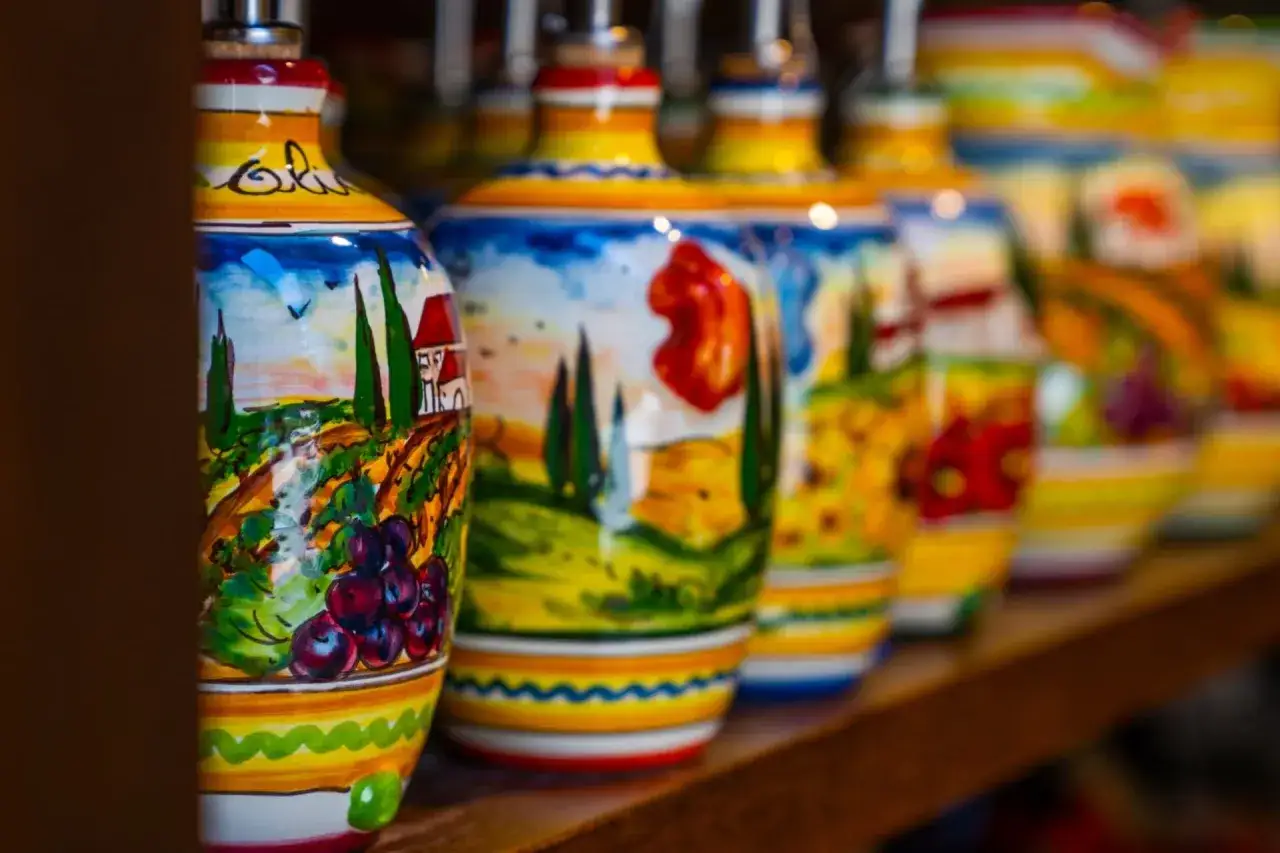 Kolorowe, ręcznie malowane butelki z motywami włoskiego krajobrazu. Idealne, by znaleźć gdzie kupić pamiątki w Rzymie.