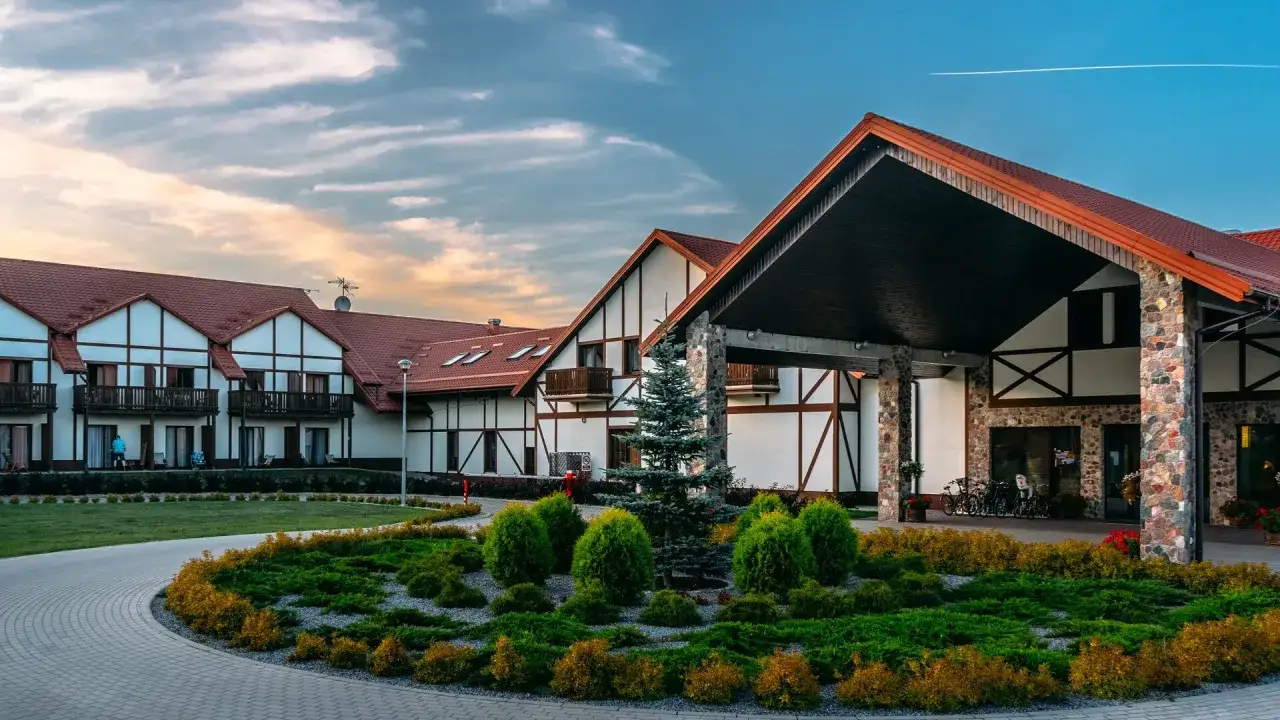 Malowniczy mikołajki resort spa z charakterystyczną architekturą i zadbanym ogrodem.