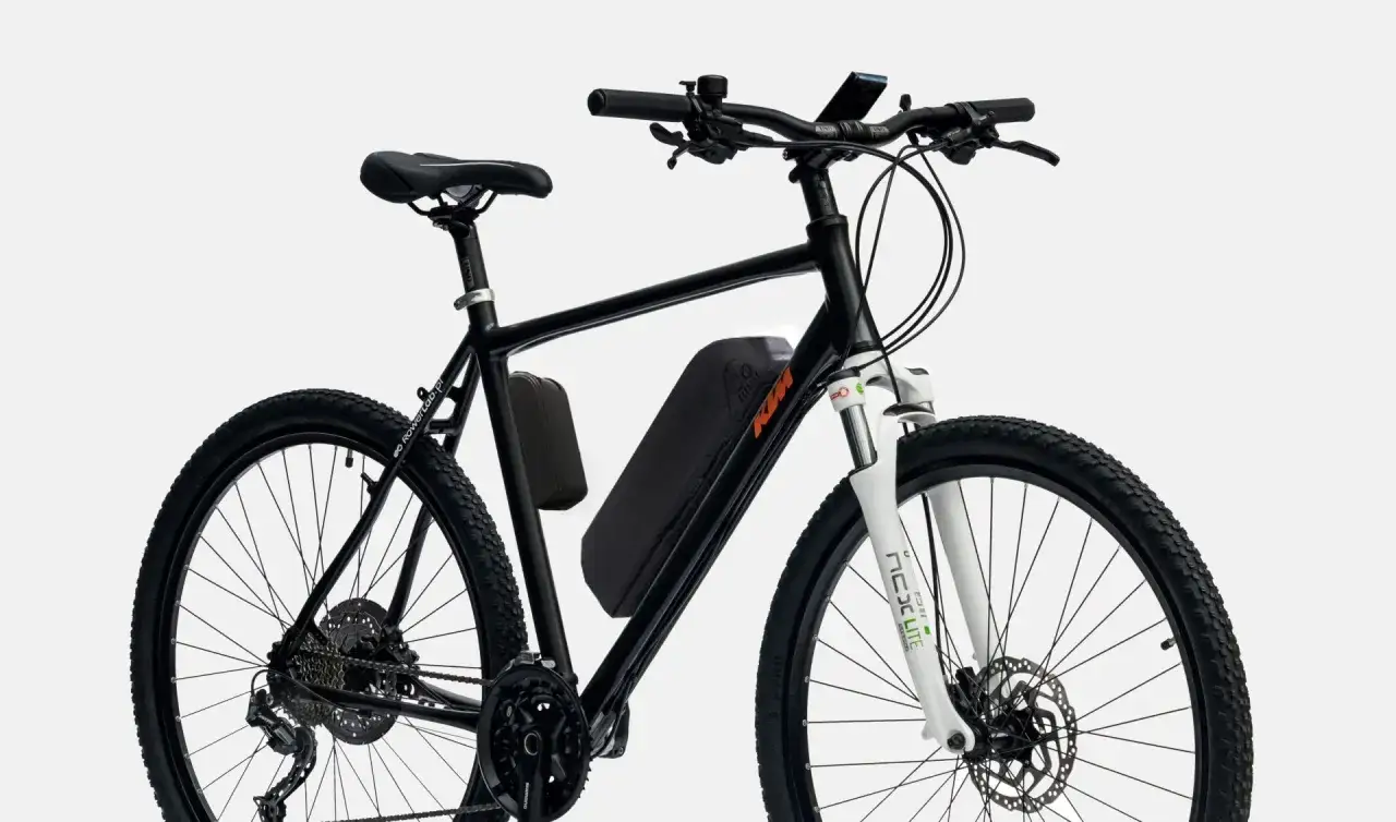 Czarny rower z zamontowanym, **tani zestaw do konwersji roweru** na elektryczny. Bateria umieszczona w trójkącie ramy.