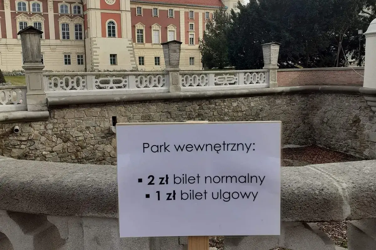 Pałac w Łącku zaprasza na zwiedzanie! Tablica informuje o cenach biletów do parku wewnętrznego: 2 zł normalny, 1 zł ulgowy.