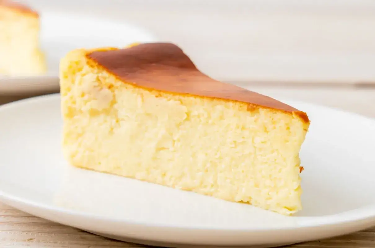 Kawałek puszystego sernika wiedeńskiego z lekko przypieczoną skórką. Idealny przepis, jak zrobić sernik wiedeński.