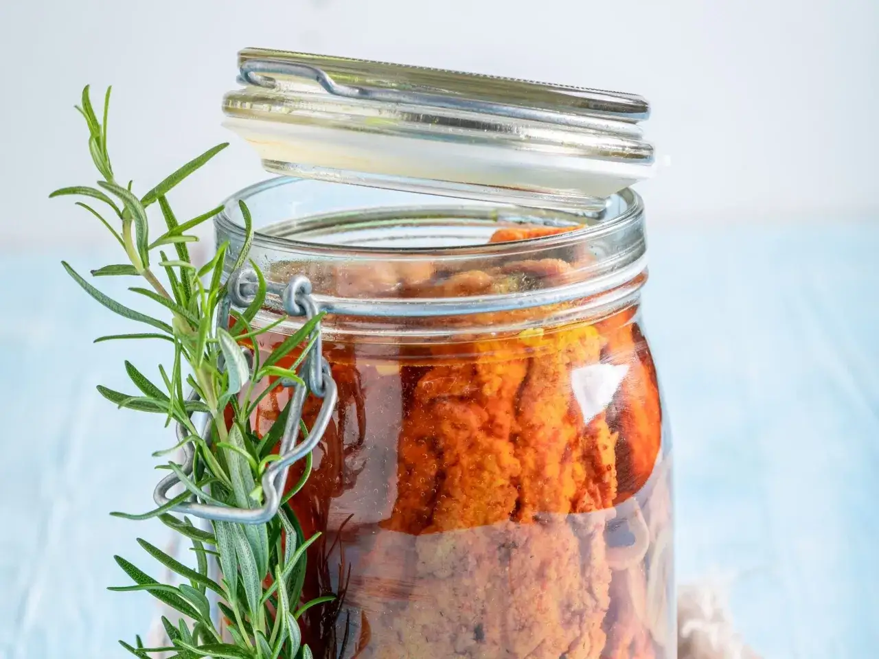 Słoik z przynętą na ryby i gałązką rozmarynu.