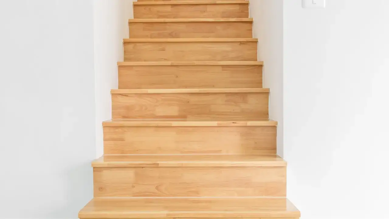 Jasne, drewniane stopnie tworzą praktyczne ściany na klatce schodowej, dodając ciepła i stylu.