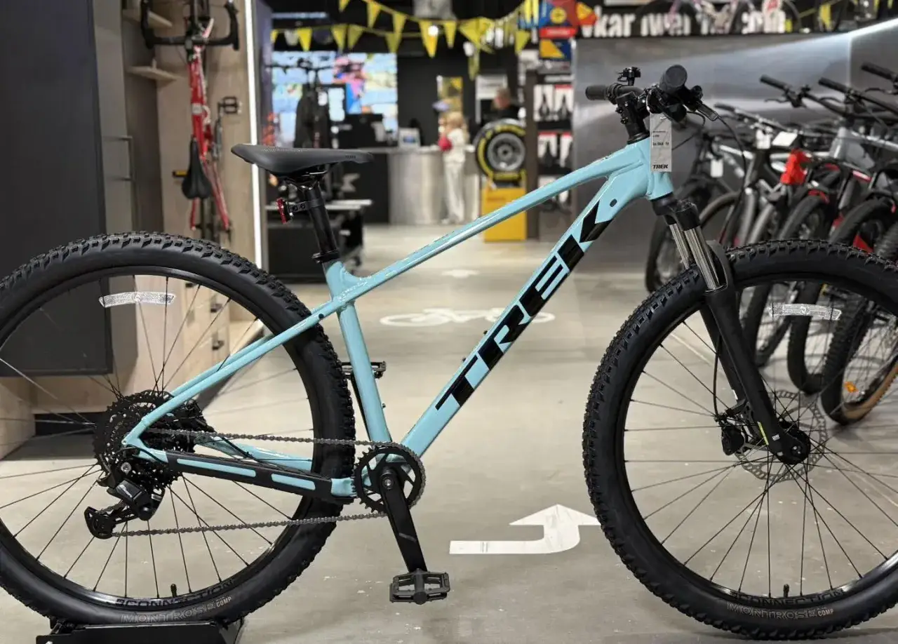 Jasnoniebieski rower górski Trek Marlin 4 z czarnym napisem TREK na ramie, gotowy na przygodę.