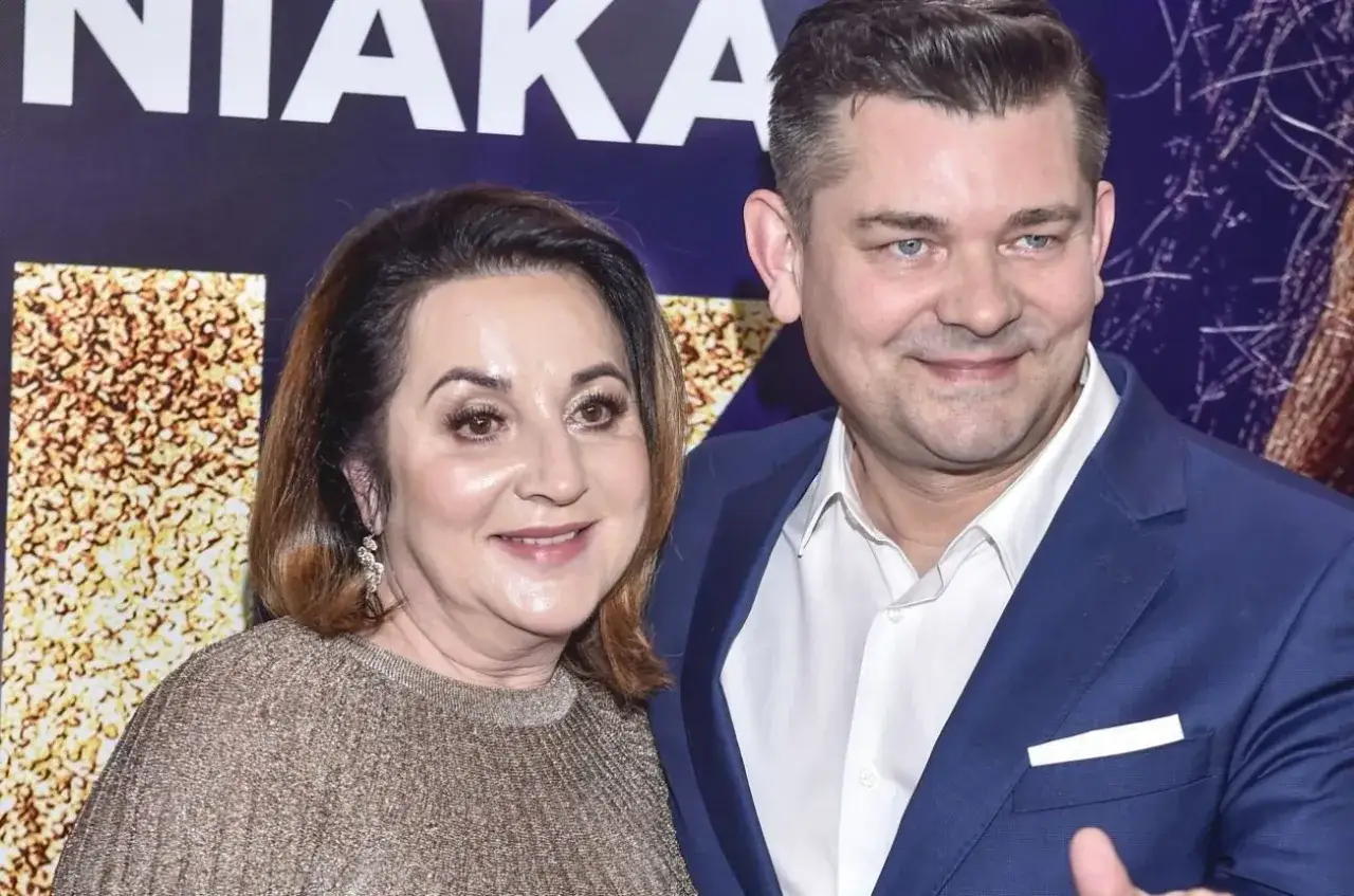 Danuta i Zenek Martyniuk pozują do zdjęcia. Kobieta ma złoty sweter, mężczyzna niebieski garnitur.