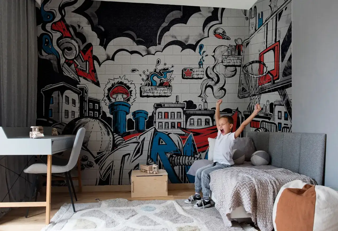 Chłopiec cieszy się w pokoju z dynamicznym **graffiti w pokoju** na ścianie, przedstawiającym miasto i elementy koszykówki.