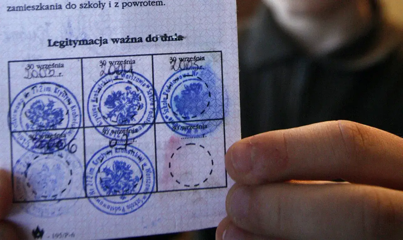 Widok na legitymację szkolną z pieczątkami. Widać daty i okrągłe pieczątki z godłem Polski.