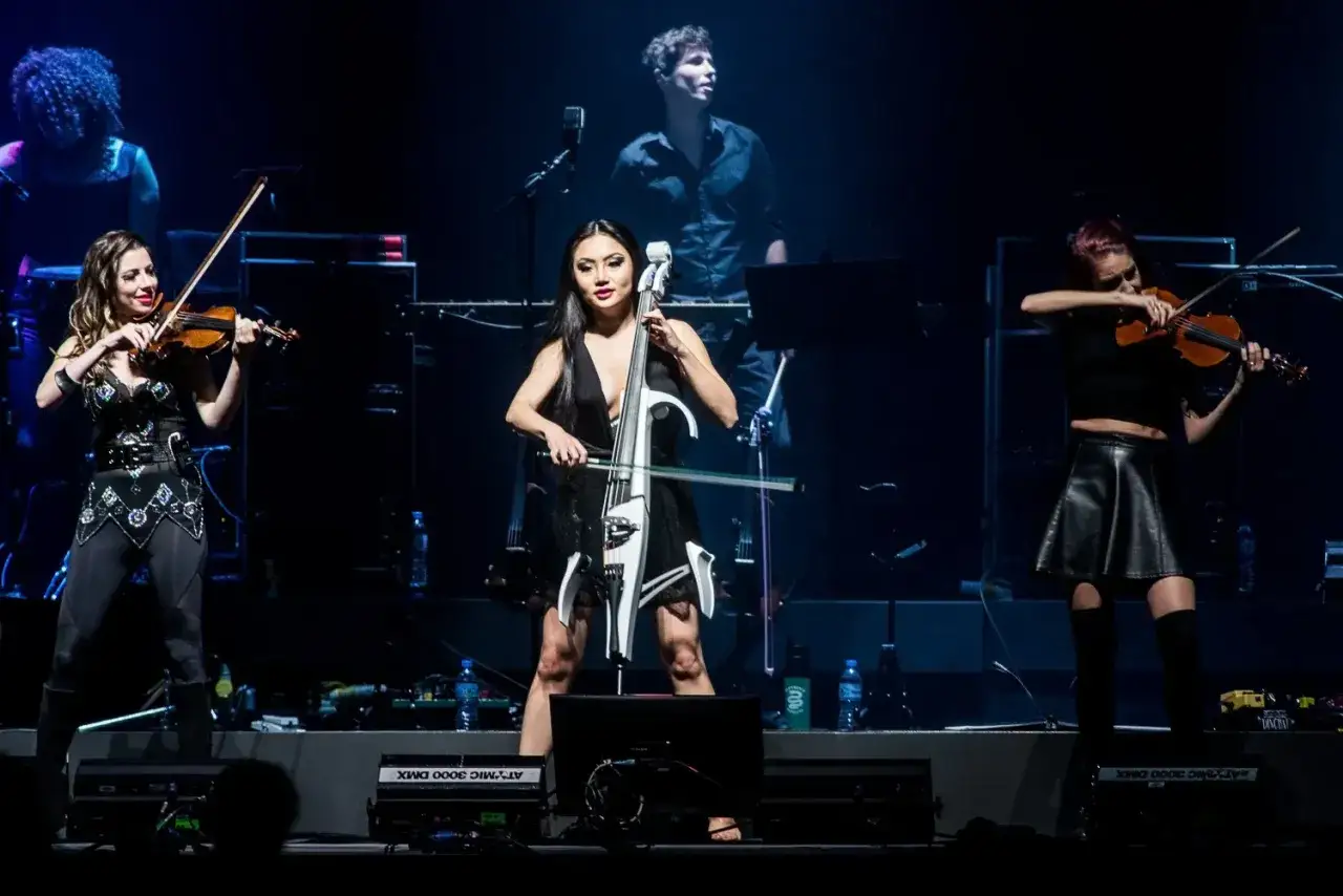 Trzy artystki grają na instrumentach smyczkowych podczas koncertu. Zastanawiasz się, ile trwa koncert Hansa Zimmera?