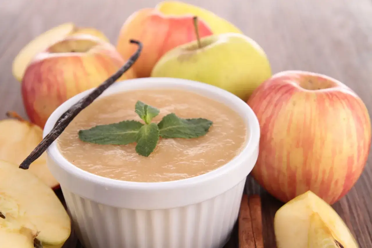 Jak usztywnić mus jabłkowy? Oto pyszny mus jabłkowy z wanilią i miętą, otoczony świeżymi jabłkami.