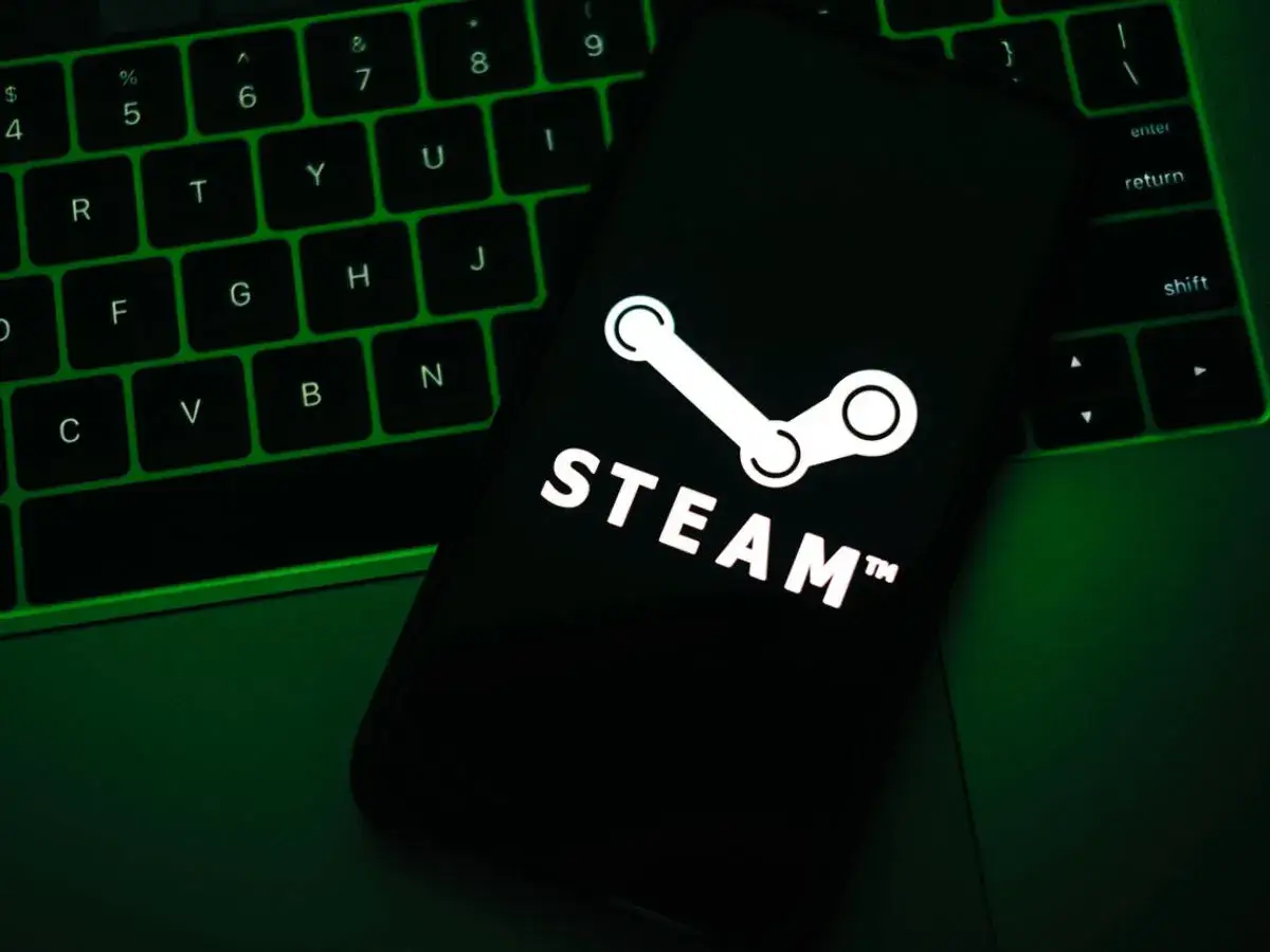 Telefon z logo Steam na tle zielonej klawiatury.
