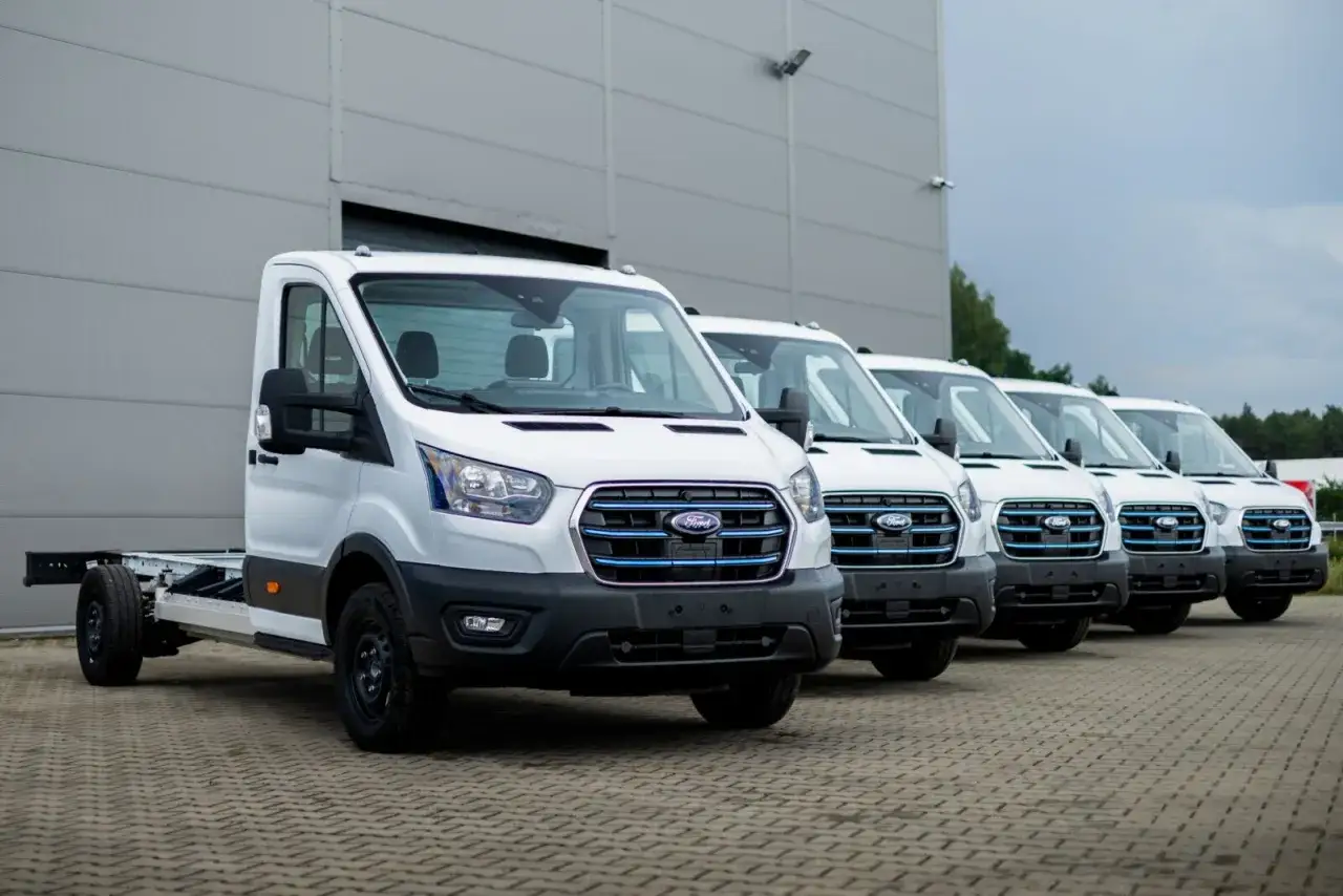 Rząd białych Fordów Transit, gotowych do pracy. Zastanawiasz się, ile waży bus dostawczy? Te modele czekają na zabudowę.