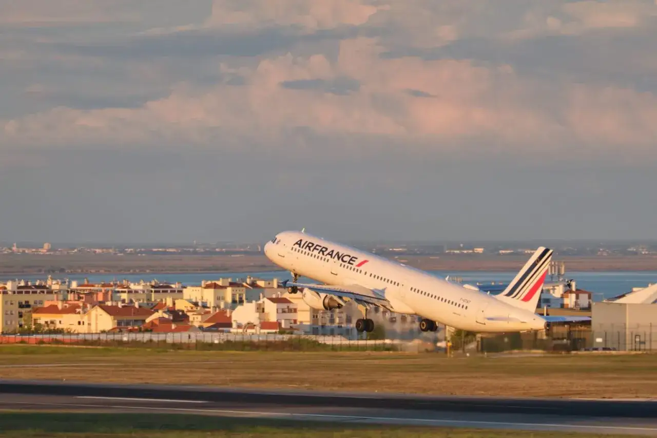 Samolot Air France startuje na tle miasta i morza.