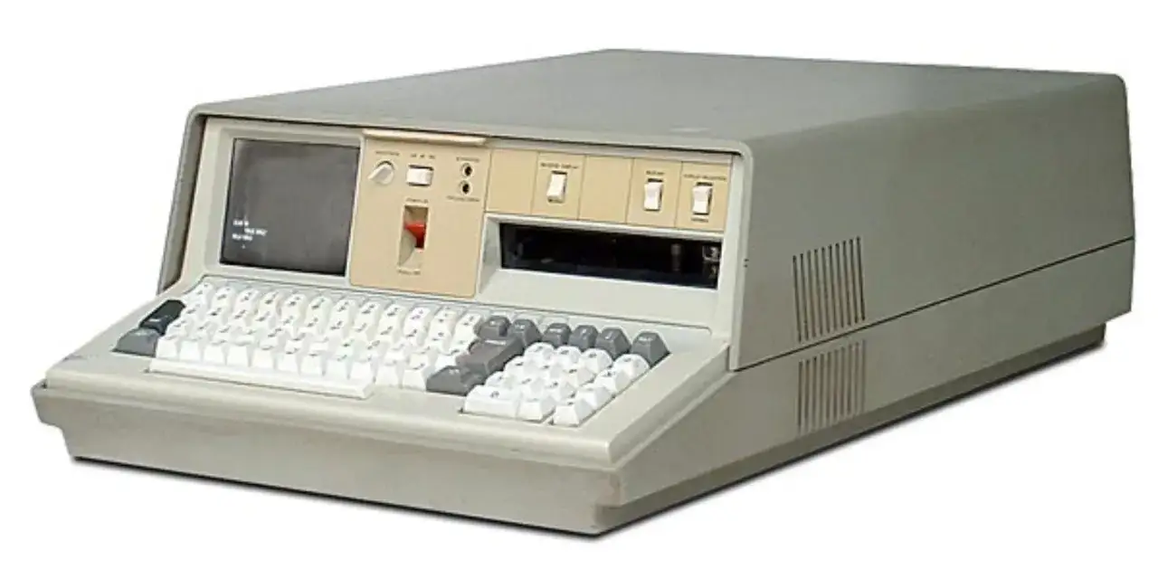 Stary komputer z klawiaturą i małym ekranem.