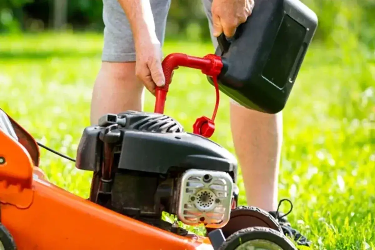 Osoba nalewa paliwo do kosiarki Briggs & Stratton. Użyj benzyny bezołowiowej 95.