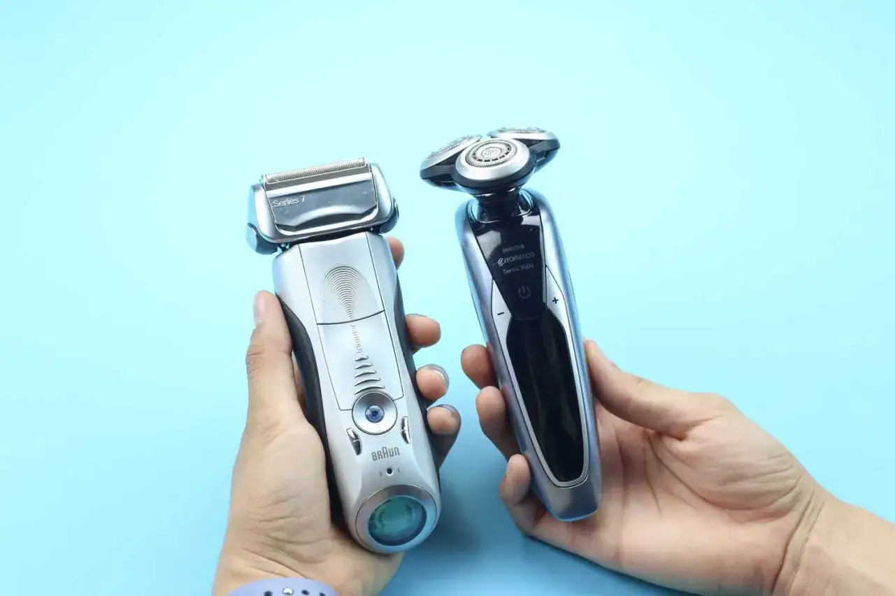 Dwie golarki elektryczne, Braun Series 7 i Philips Norelco Series 9000, trzymane w dłoniach na niebieskim tle.