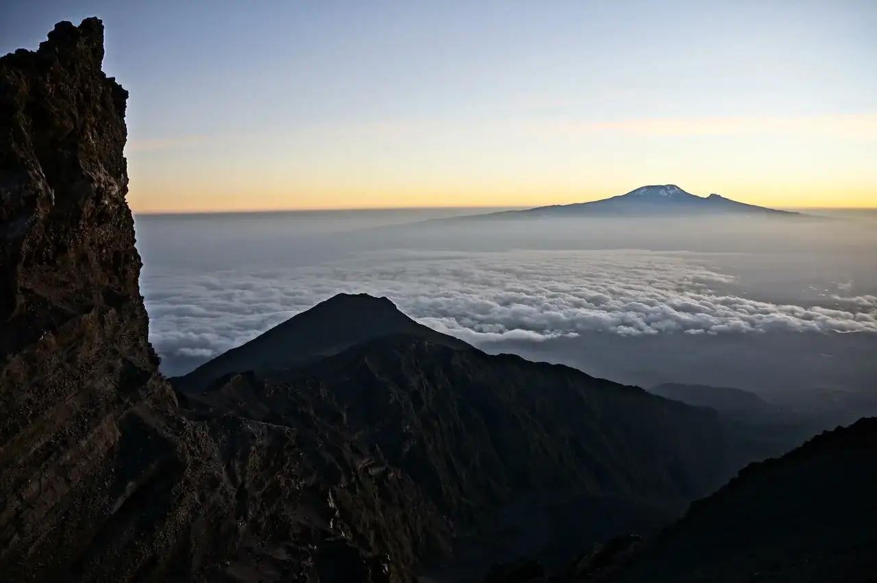 Widok z góry na morze chmur, z górującym w oddali majestatycznym Mount Meru.