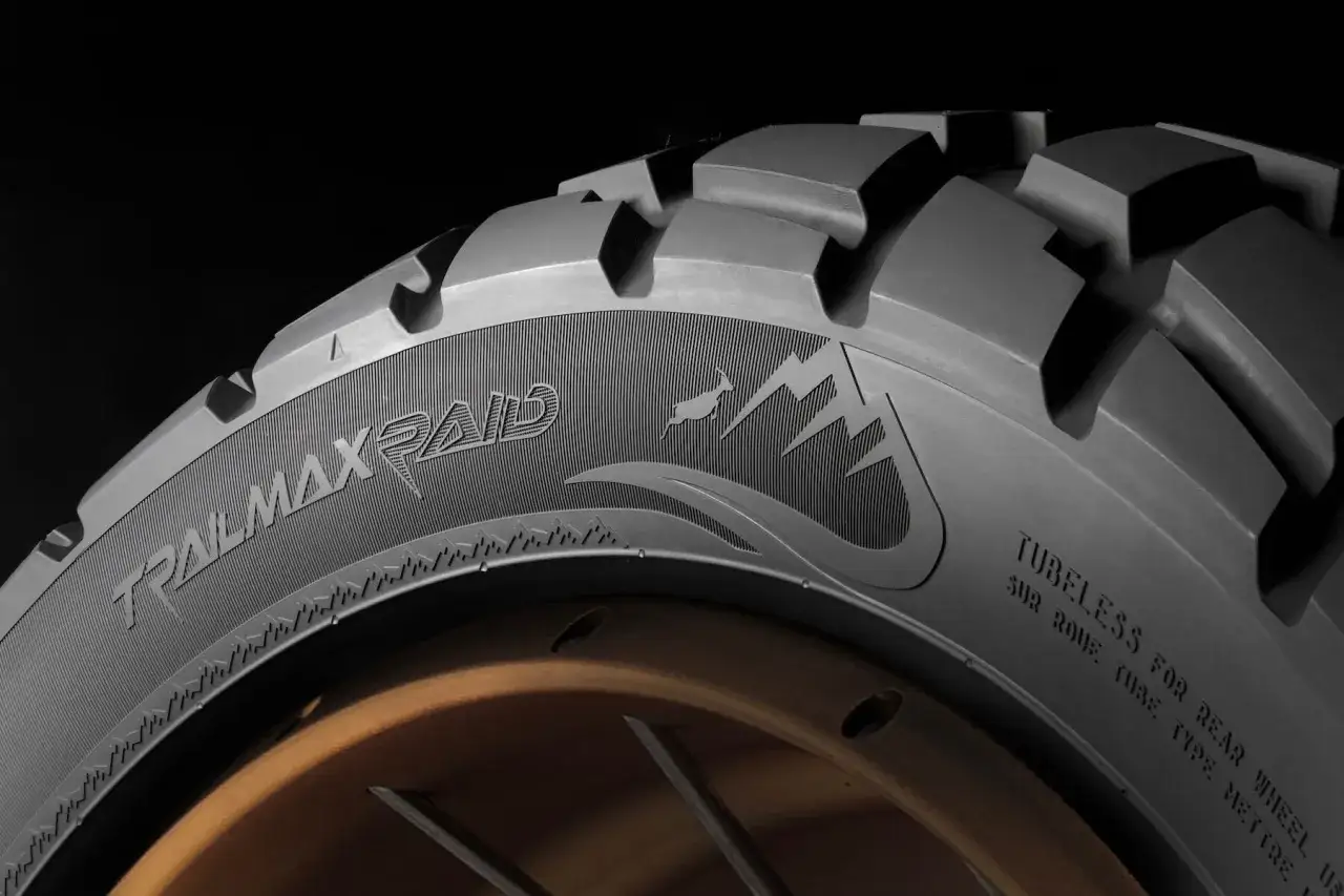 Opona motocyklowa Dunlop Trailmax Raid z agresywnym bieżnikiem i grafiką górską, gotowa na każdą wyprawę.
