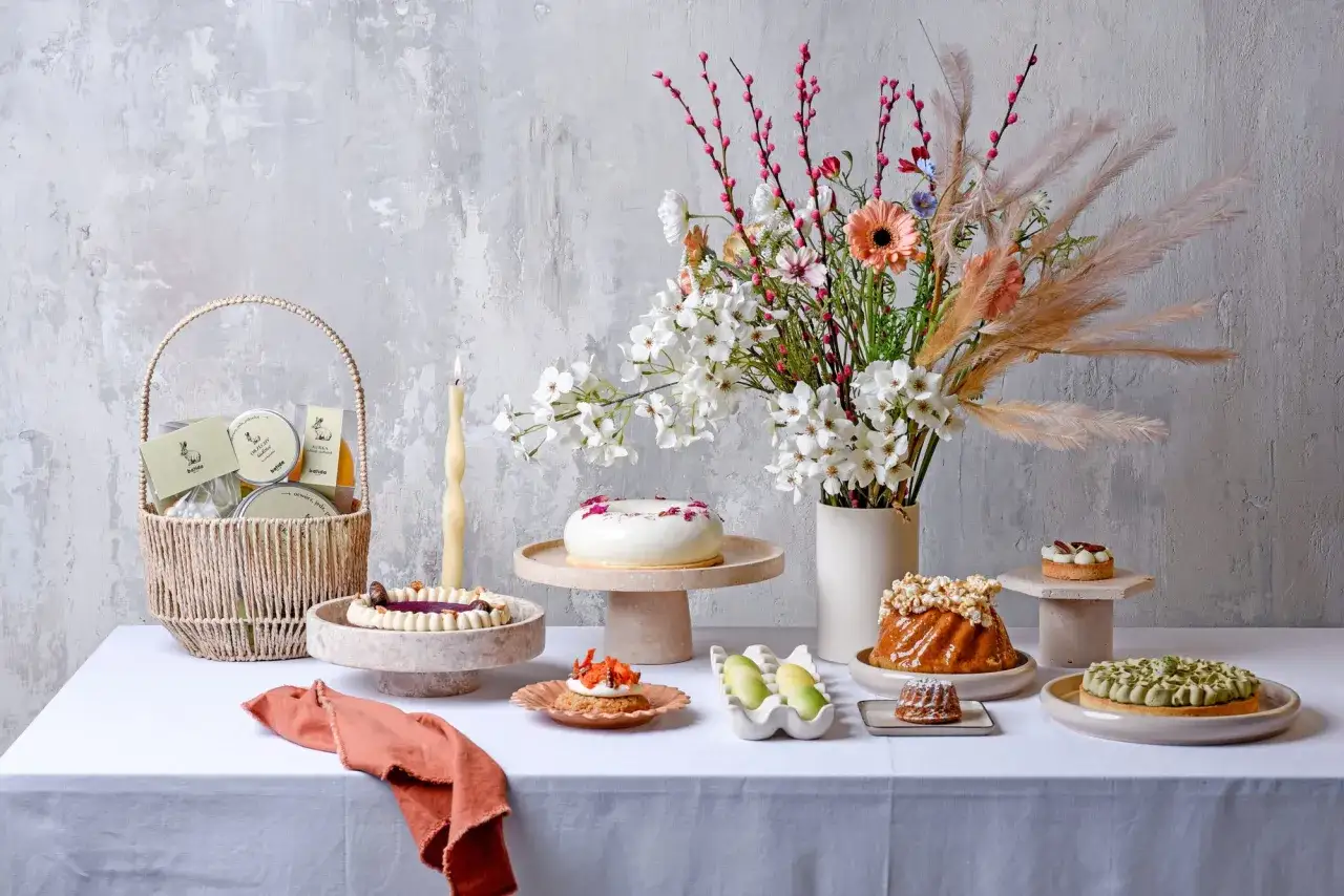 Stół pełen słodkości: torty, babeczki, koszyk z upominkami. Zastanawiasz się, ile kosztuje tort urodzinowy?