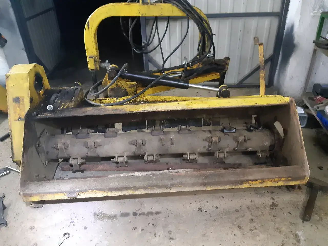 Żółty wał do kosiarki bijakowej z widocznymi nożami i mocowaniami. Może posłużyć jako baza do samodzielnego wykonania wału.