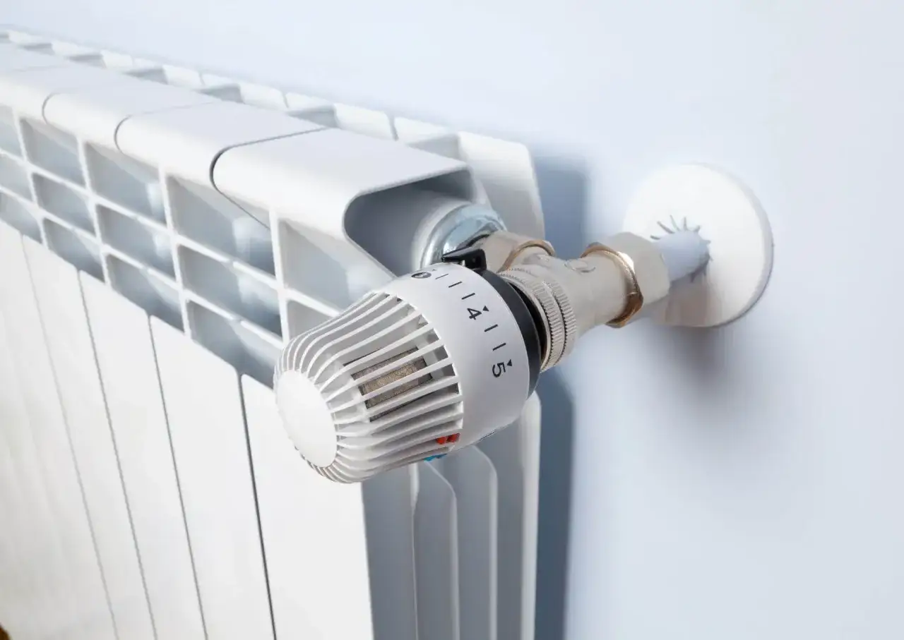 Biały grzejnik z termostatem. Idealne rozwiązanie, jeśli zastanawiasz się, jakie ogrzewanie do domu 70m2 wybrać.