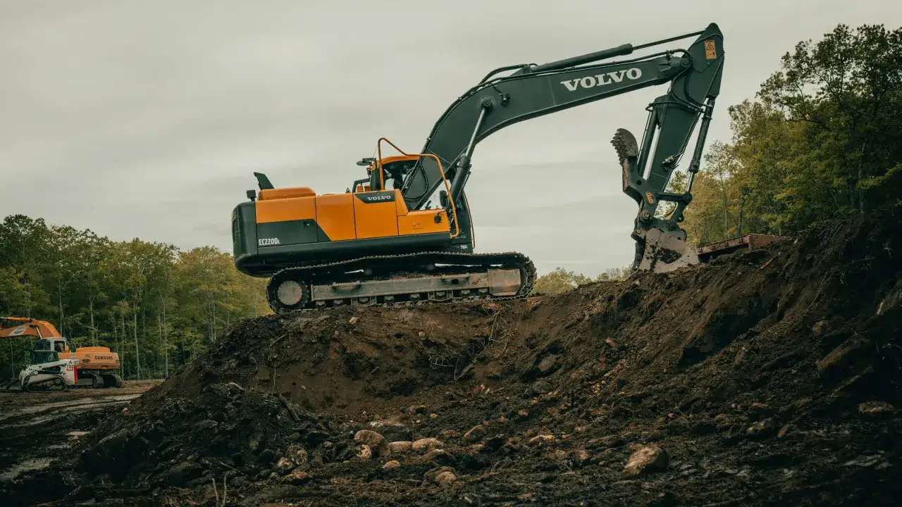 Duża koparka Volvo pracuje na budowie. Zastanawiasz się, ile zarabia operator koparki?