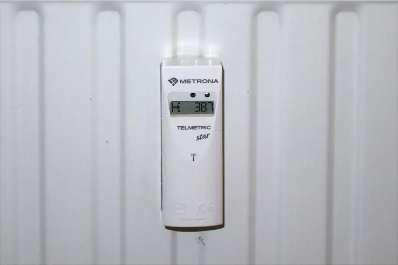 Biały licznik ciepła Metrona Telmetric star na grzejniku. Odczyt 387. Prosty sposób, jak odczytać licznik centralnego ogrzewania.