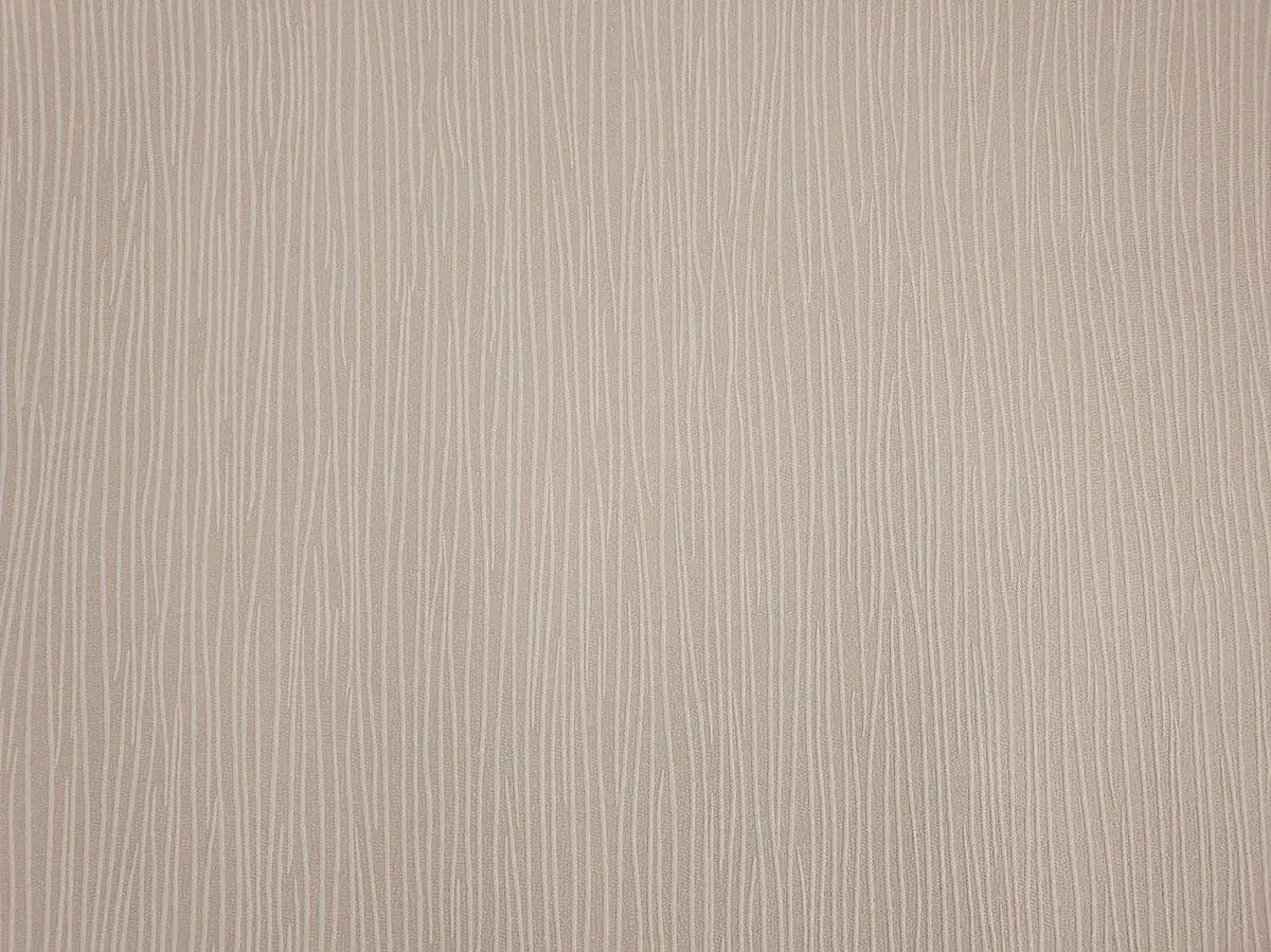 Jasna, beżowa tapeta wypukła z subtelnym, pionowym wzorem przypominającym delikatne pociągnięcia pędzla.