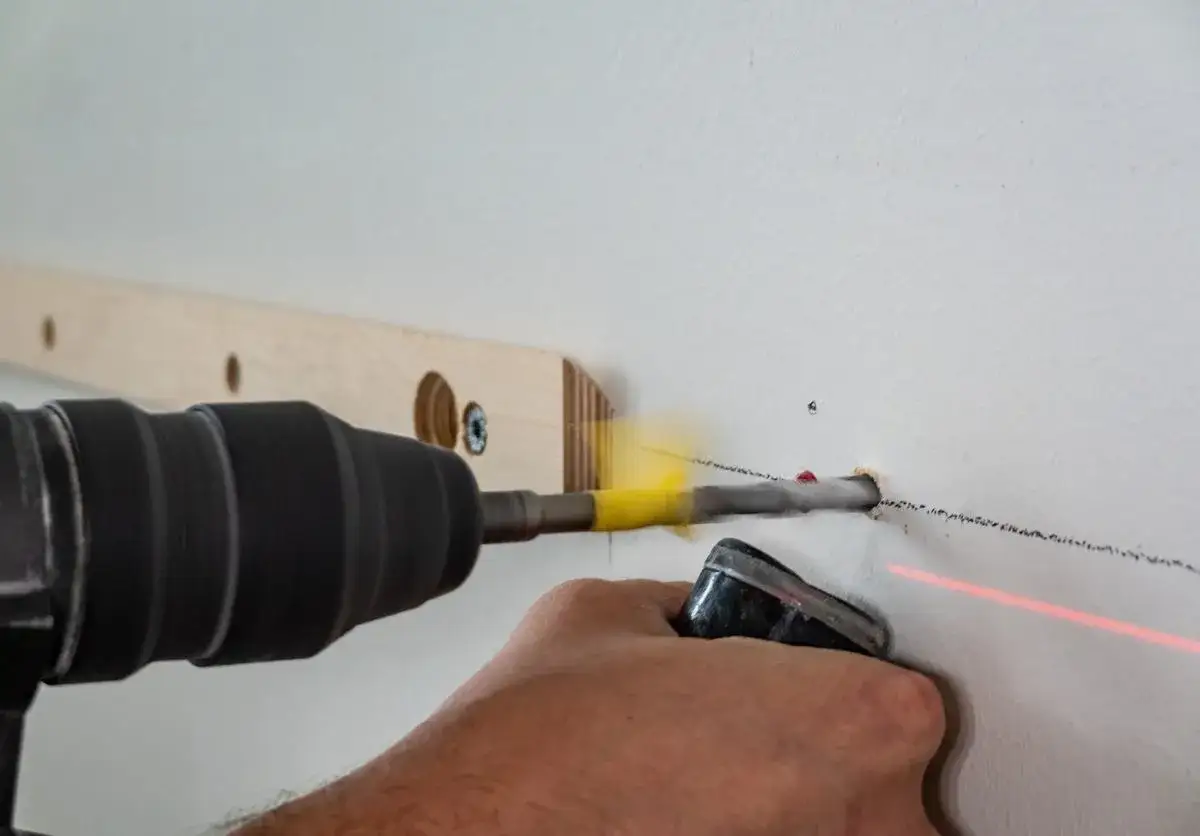 Wiertarka wierci w ścianie. Czy w niedzielę można wiercić w bloku? To pytanie nurtuje wielu.