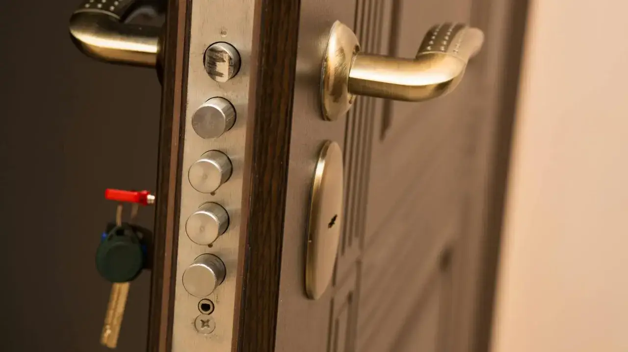 Klucze wiszą przy wielozamkowym systemie drzwi, pokazując jak zablokować drzwi żeby nikt nie wszedł.
