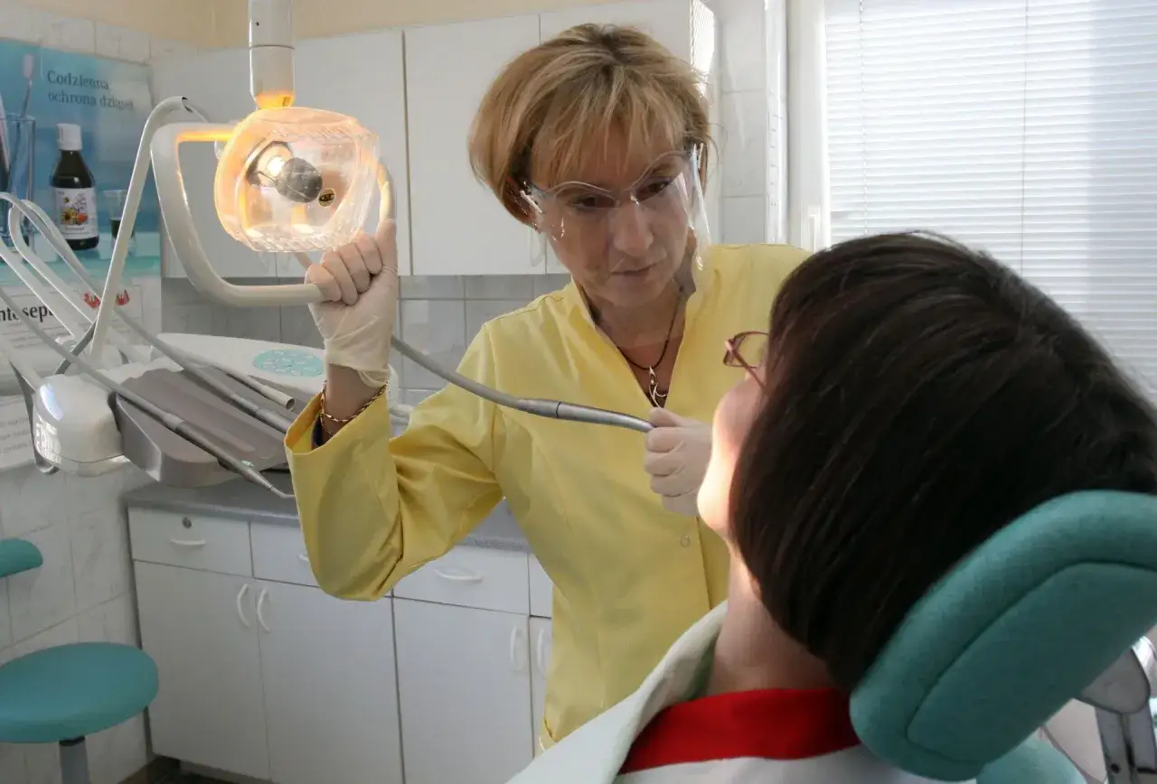 Dentystka w Koninie pomaga pacjentowi, który cierpi gdzie z bólem zęba.