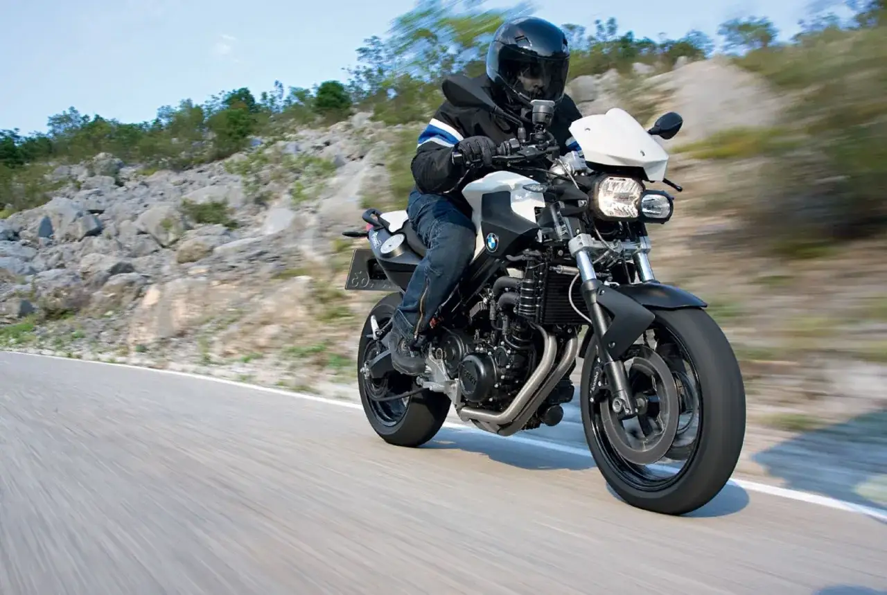 Motocyklista w kasku jedzie na BMW F800R po krętej drodze. Poznaj jego dane techniczne.