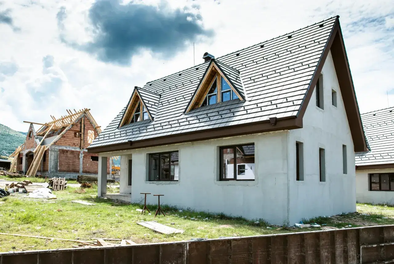 Dwa domy w budowie, jeden z dachem i oknami, drugi w stanie surowym. Idealne miejsce, by zacząć myśleć, jak sprzedać dom.