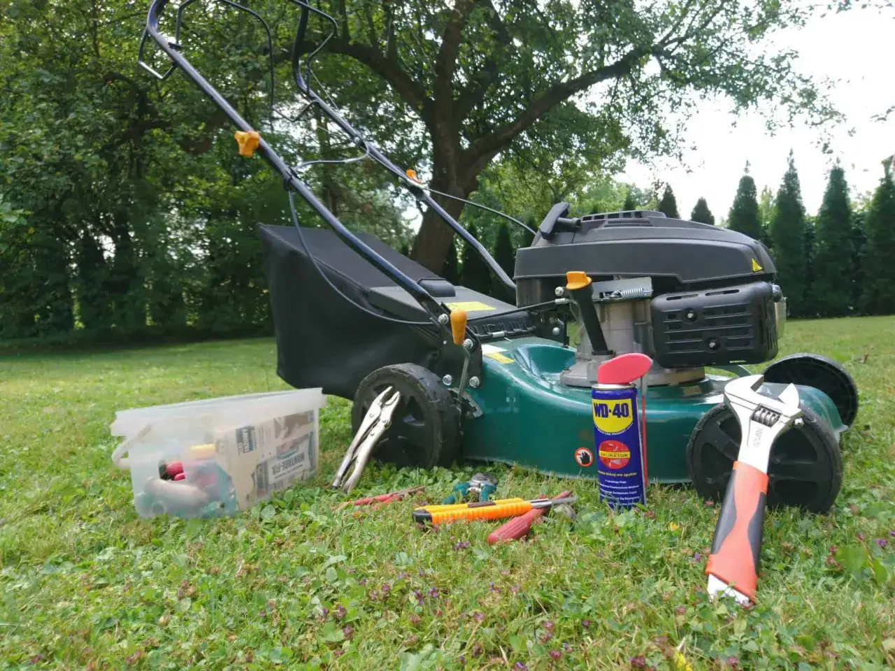 Narzędzia do koszenia trawy i instrukcja, jak zdjąć koło w kosiarce.