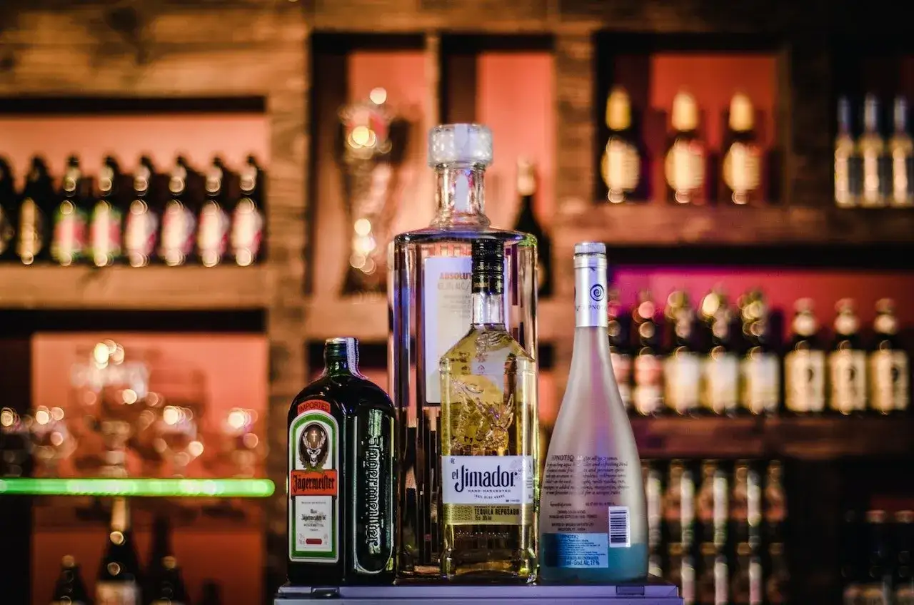 Jägermeister z sokiem jabłkowym i innymi alkoholami na barze.