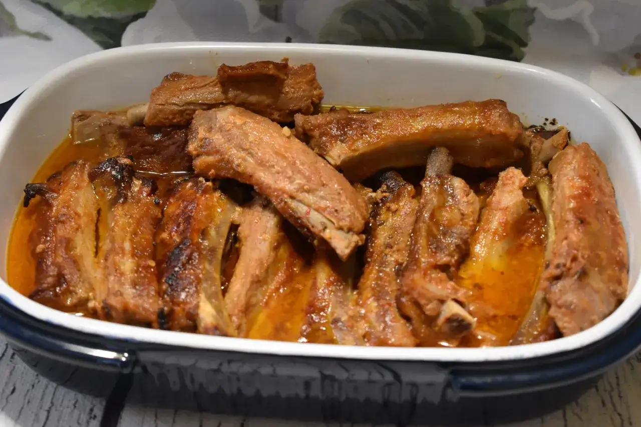 Pieczone żeberka w sosie w naczyniu żaroodpornym.