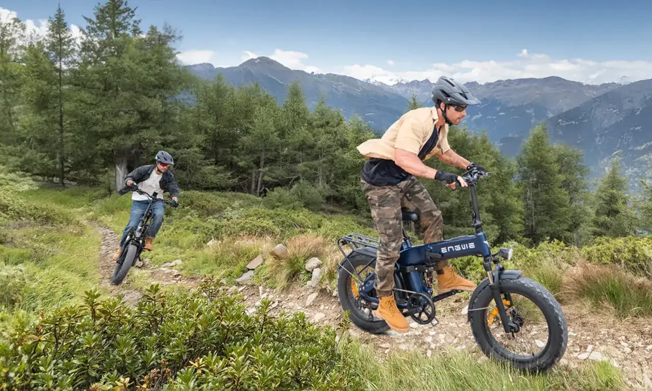 Dwóch mężczyzn na rowerach elektrycznych z grubymi oponami pokonuje górski szlak. Ten rower daje niesamowity boost na podjazdach.