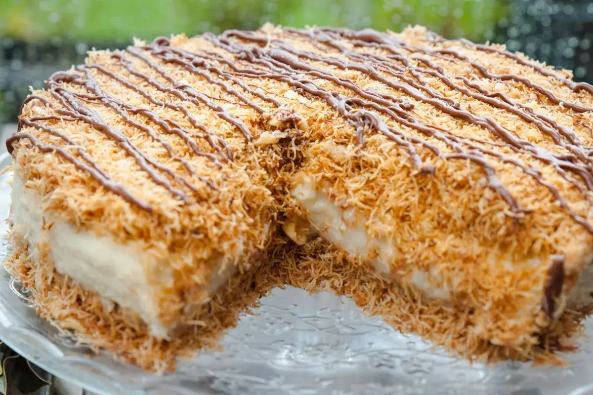 Pyszny deser Kunafa przepis. Chrupiąca, złocista skórka z cienkich nitek ciasta, przełożona kremowym nadzieniem i polana czekoladą.