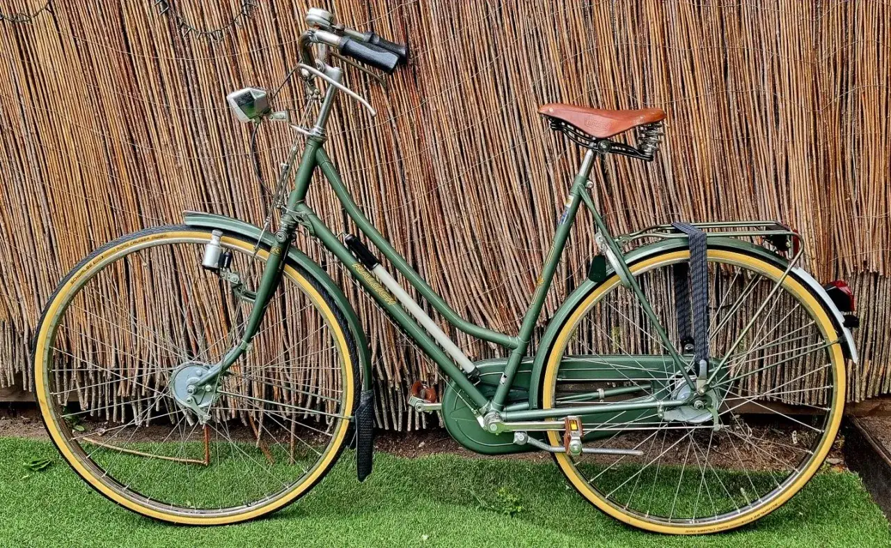 Zielony rower Raleigh, klasyczny model z brązowym siodełkiem Brooks, gotowy na miejskie przygody. Raleigh rower co to za firma? To brytyjska legenda.