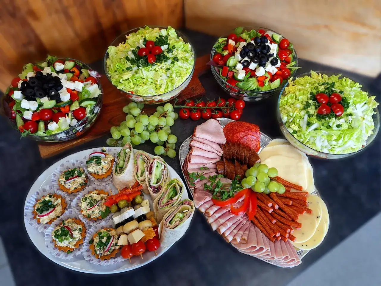 Pyszne przekąski i sałatki na talerzach. Zastanawiasz się, ile kosztuje catering do domu? To idealna opcja na imprezę!