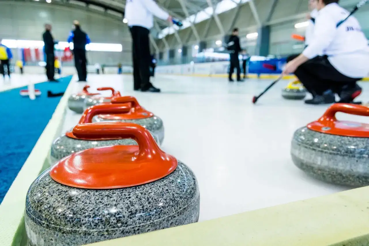 Kamienie do curlingu, każdy ważący ok. 20 kg, czekają na lodzie.
