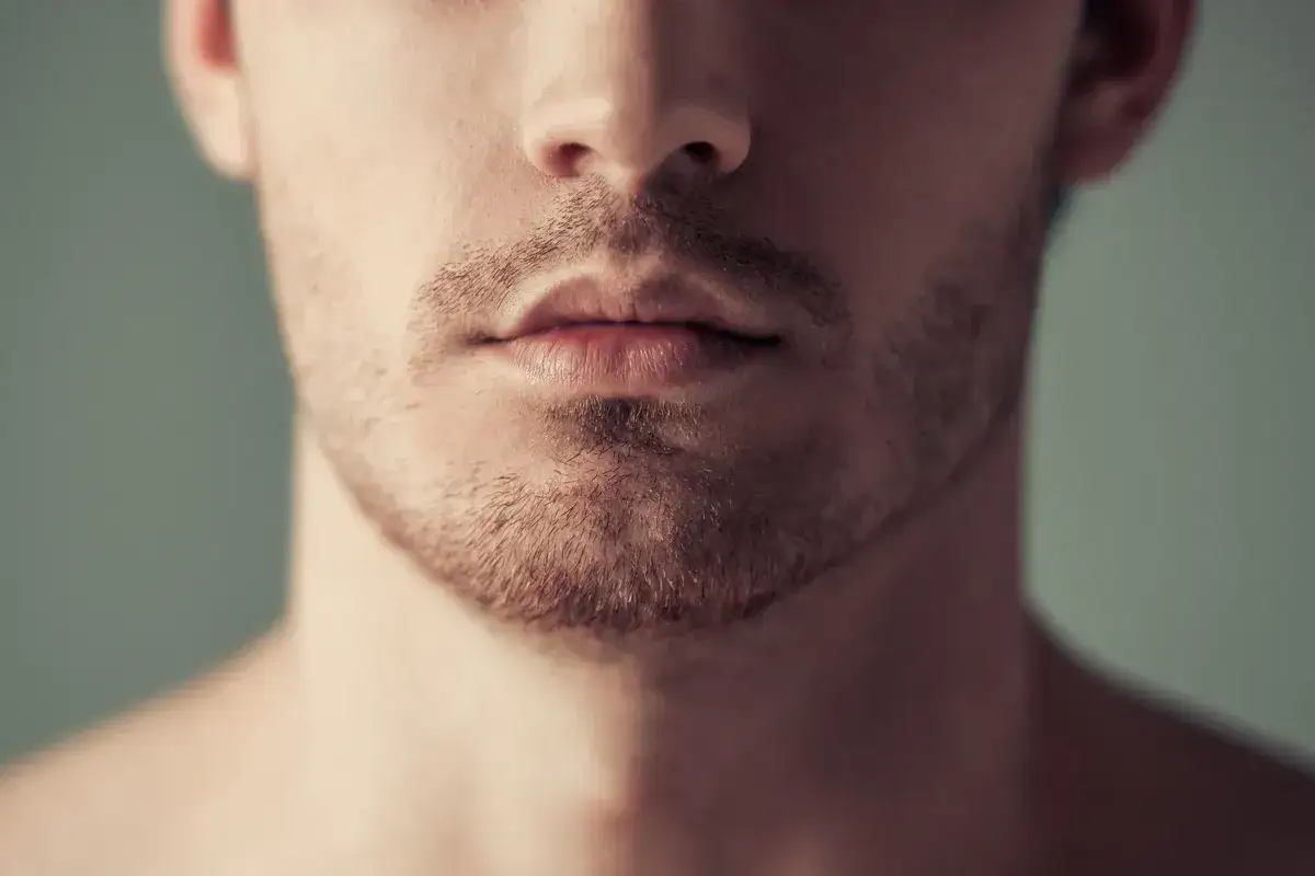 Zbliżenie na usta i zarost mężczyzny.