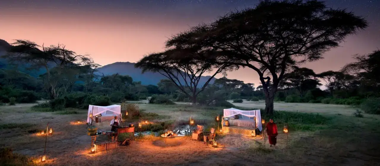 Nocleg pod gwiazdami w Afryce. Romantyczna kolacja przy ognisku i łóżko pod baldachimem, oświetlone latarniami.