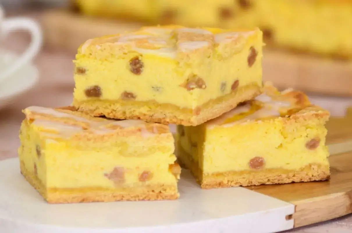 Sernik z wiaderka który zawsze wychodzi, puszysty, żółty, z rodzynkami i lukrem, pokrojony na kwadraty.
