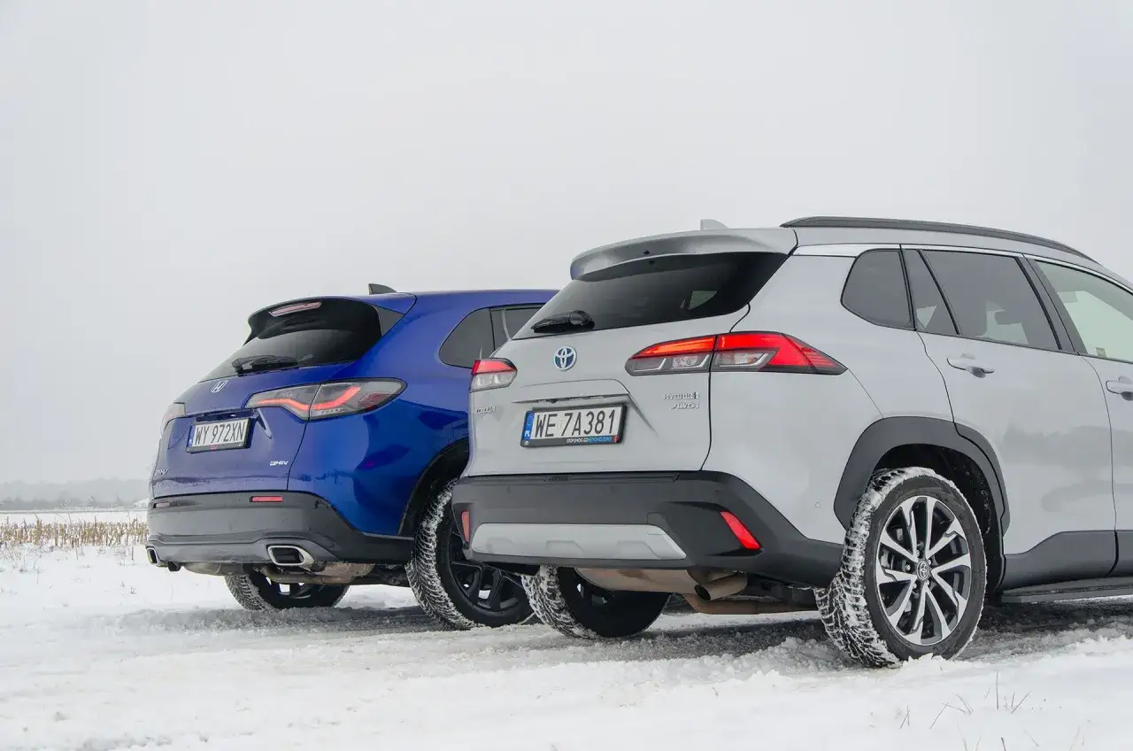 Porównanie hybryd: niebieska Honda CR-V e:HEV i srebrna Toyota Corolla Cross Hybrid AWD na śniegu. Którą wybrać?