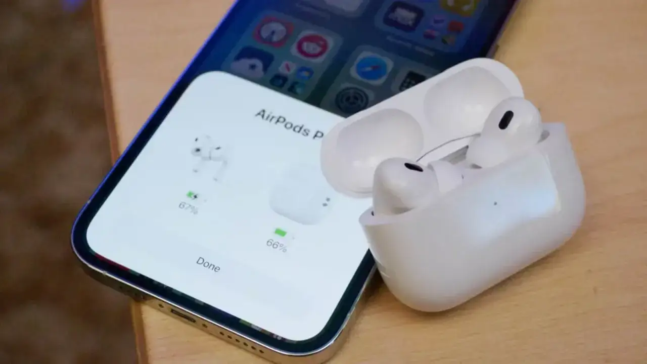 iPhone z otwartym etui AirPods Pro, pokazującym stan naładowania słuchawek.