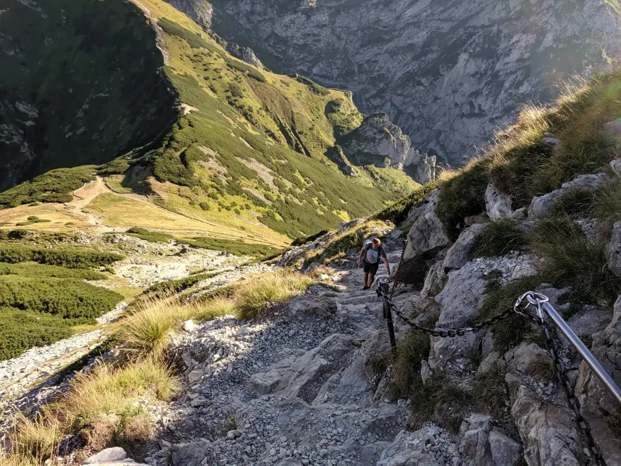 Turysta pokonuje kamienisty szlak z łańcuchami. Czy szlak na Giewont jest trudny? Ten odcinek wymaga ostrożności i dobrej kondycji.