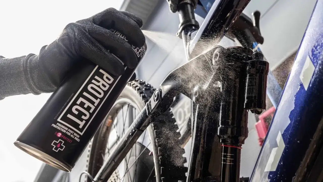Rękawica z puszką "PROTECT" rozpyla środek na ramę roweru elektrycznego, pokazując, jak myć rower elektryczny.
