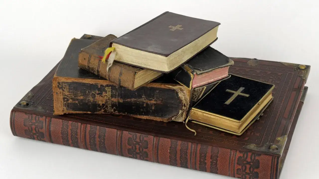 Stapel alter Bücher, einige mit Kreuzen auf dem Einband.