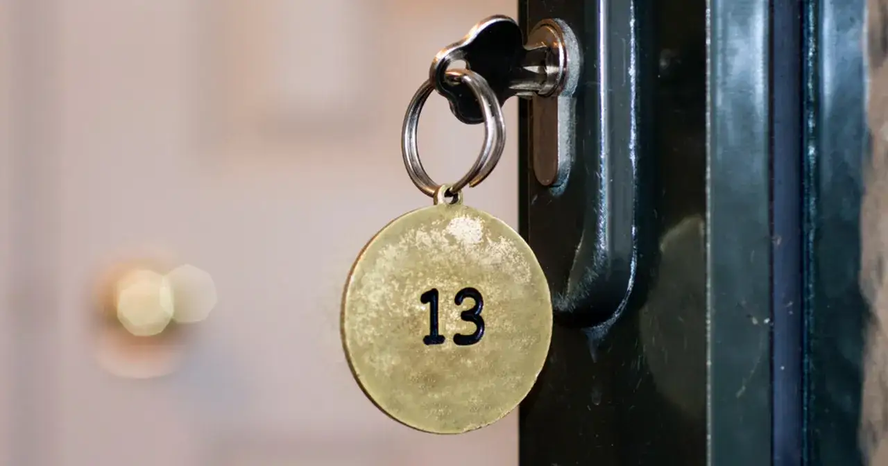 Klucz z okrągłą zawieszką z numerem 13 włożony do zamka.